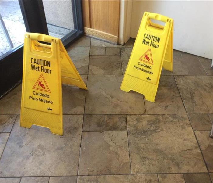 Caution signs around water leak.