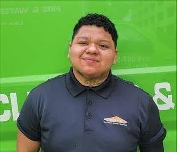 Man Standing Infront of Green Truck Smiling