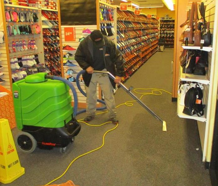 SERVPRO employee extracting water from a business' floor